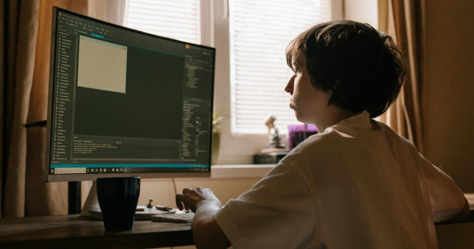 boy in white long sleeve shirt playing computer game