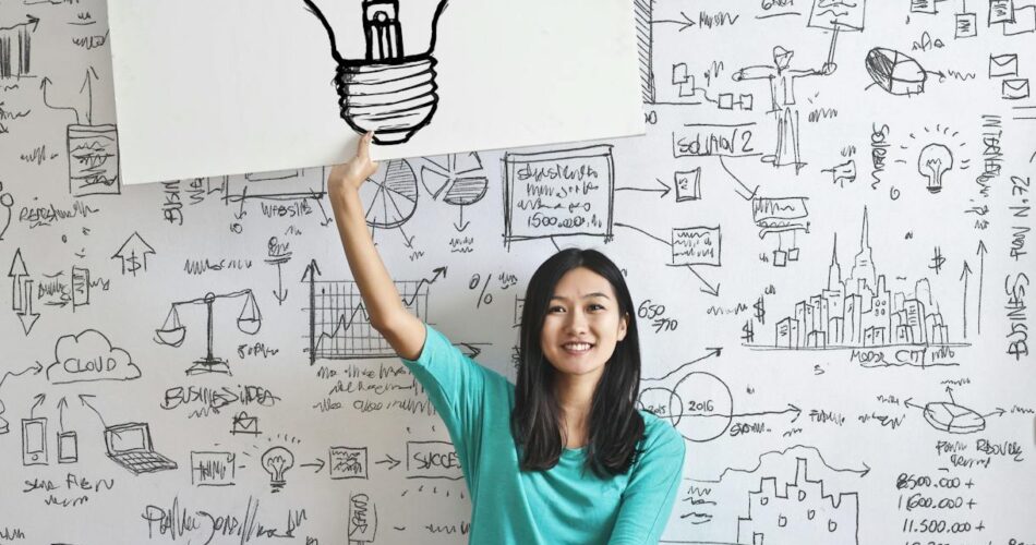 woman draw a light bulb in white board