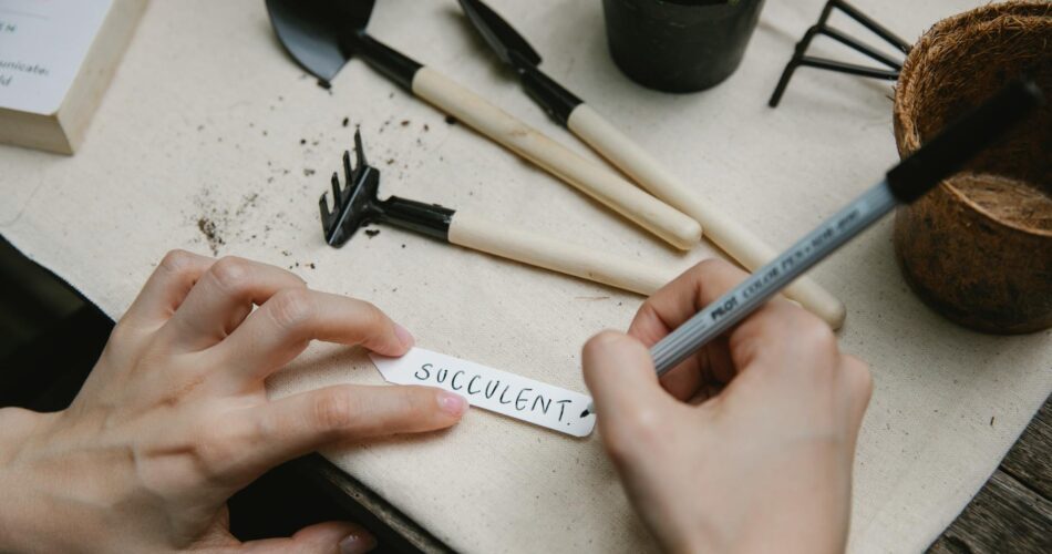 person writing name of plant on tag