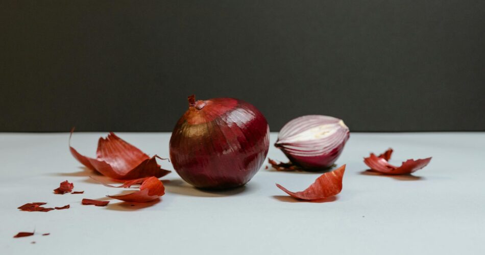 a whole and sliced onion on a white table