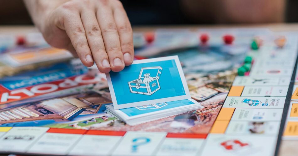 person picking monopoly cards