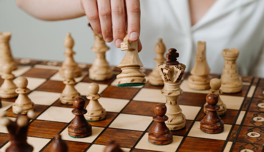 person playing chess game on chess board