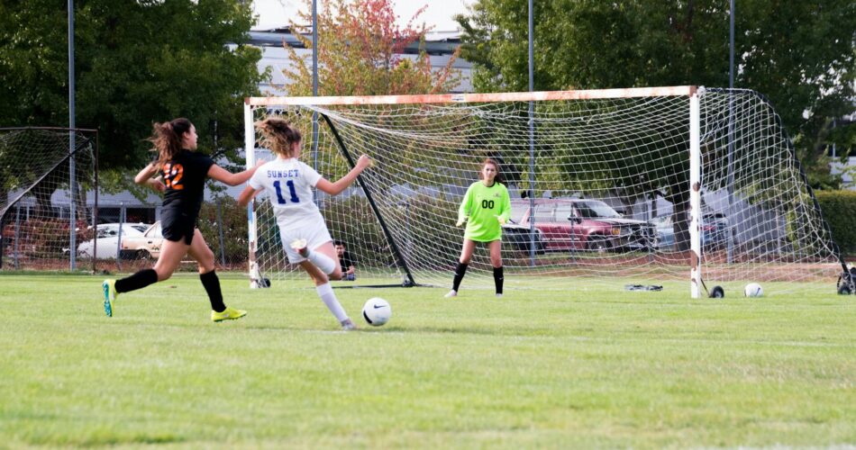 three women playing soccer game