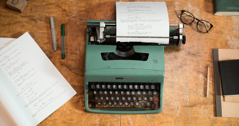 green and black typewriter on brown wooden table